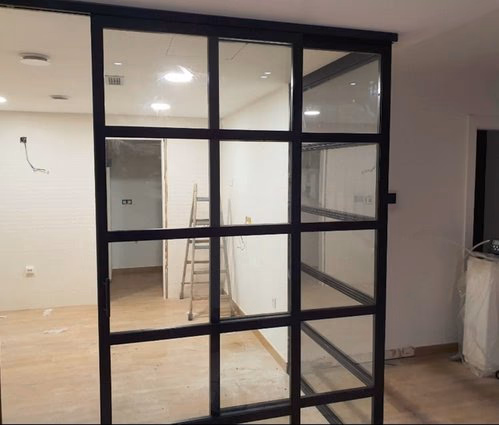 Puerta corredera metálica con vidrio para local comercial en Zaragoza