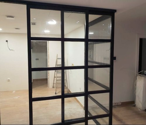 Puerta corredera metálica con vidrio para local comercial en Zaragoza